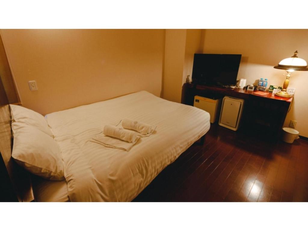 una camera d'albergo con un letto e due asciugamani di VAN CORTLANDT HOTEL - Vacation STAY 17472v ad Aira