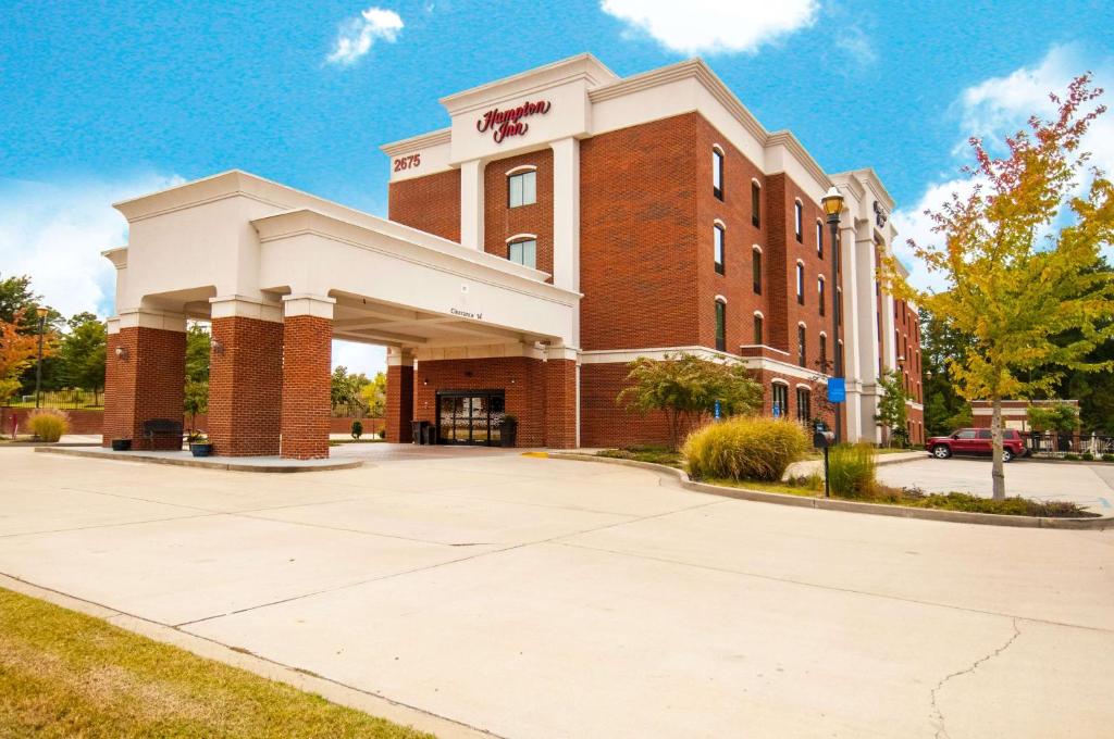 un gran edificio de ladrillo con un cartel. en Hampton Inn Hernando, MS, en Hernando