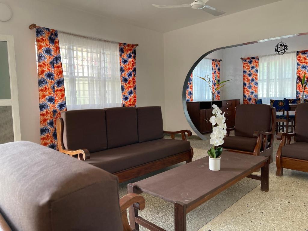 a living room with two couches and a mirror at La Villa René in Porto-Novo
