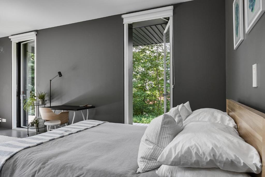 Schlafzimmer mit einem weißen Bett und einem Schreibtisch in der Unterkunft Style Meets Location in Göteborg in Göteborg
