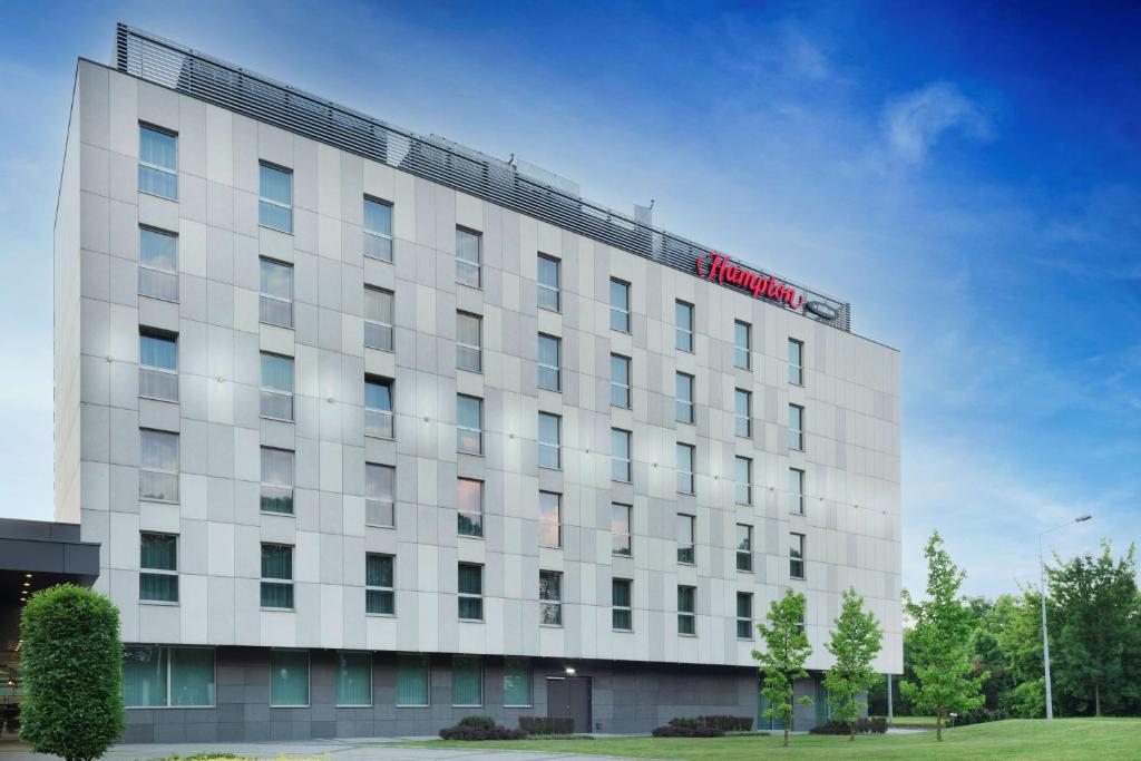 - un bâtiment blanc avec un panneau d'hôtel dans l'établissement Hampton by Hilton Krakow, à Cracovie