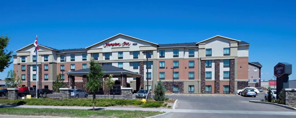 um grande hotel com um parque de estacionamento em frente em Hampton Inn Saskatoon South em Saskatoon