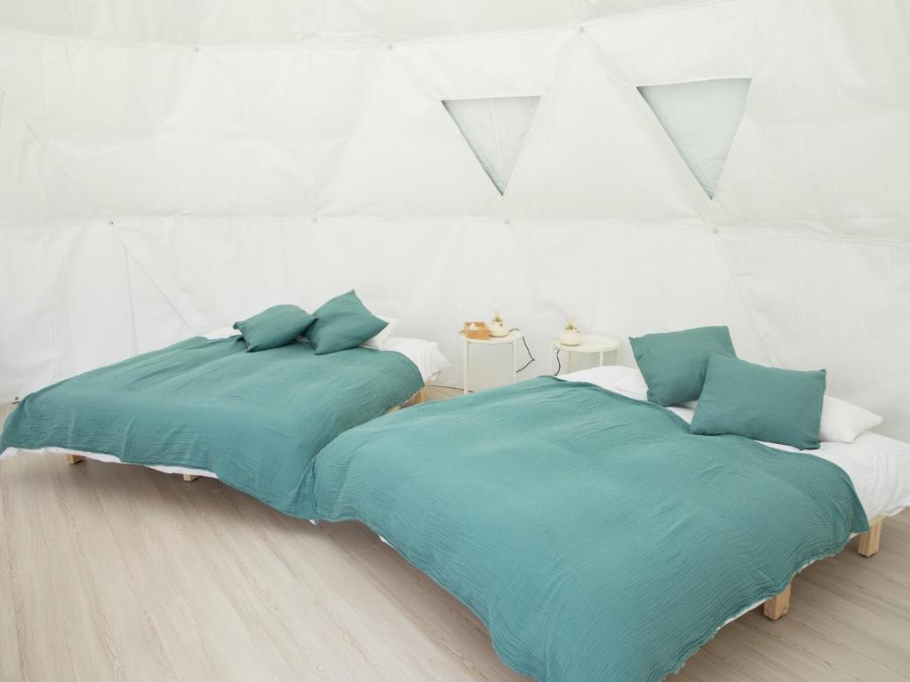 2 letti in una camera bianca con cuscini blu di BAMBOO RESORT MIHAMA TSUNAGI - Vacation STAY 43006v a Noma