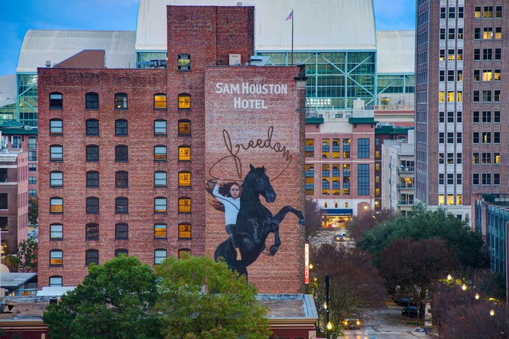 a mural of a person riding a horse on the side of a building at The Sam Houston Hotel, Curio Collection by Hilton in Houston