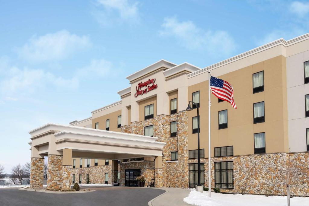 a hotel with an american flag in front of it at Hampton Inn & Suites Mount Joy/Lancaster West, Pa in Manheim