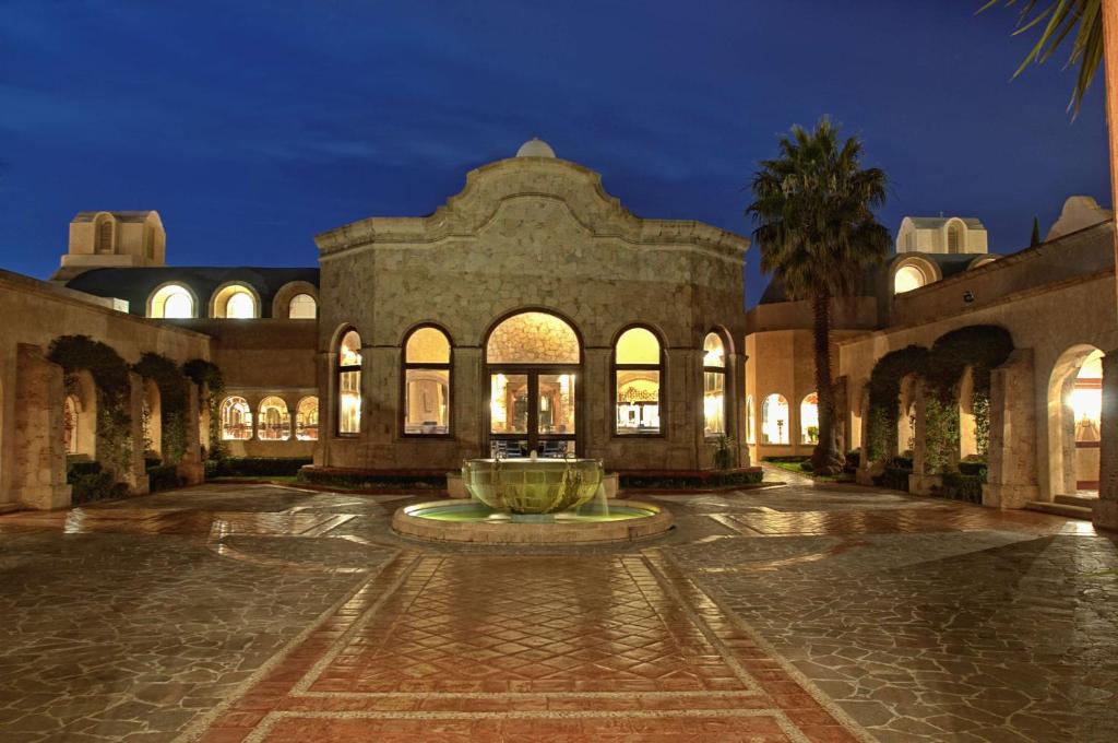 a building with a fountain in a courtyard at night at Hilton San Luis Potosi in San Luis Potosí