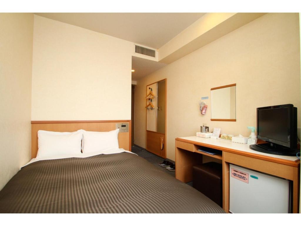 a hotel room with a bed and a television at Hotel Axia Inn Kushiro - Vacation STAY 67211v in Irifunechō