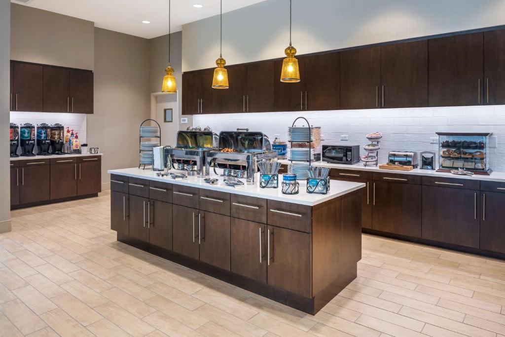 une grande cuisine avec des placards en bois et un comptoir. dans l'établissement Homewood Suites by Hilton Miami Dolphin Mall, à Miami