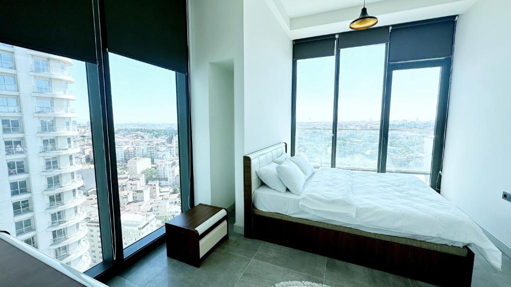 1 dormitorio con 1 cama y ventanas grandes en Ultra Lux full Residence with balcony near to Bomonti Hotel, en Estambul