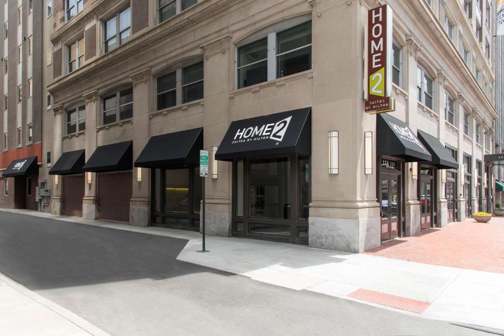 a large building with black awnings on a street at Home2 Suites by Hilton Indianapolis Downtown in Indianapolis