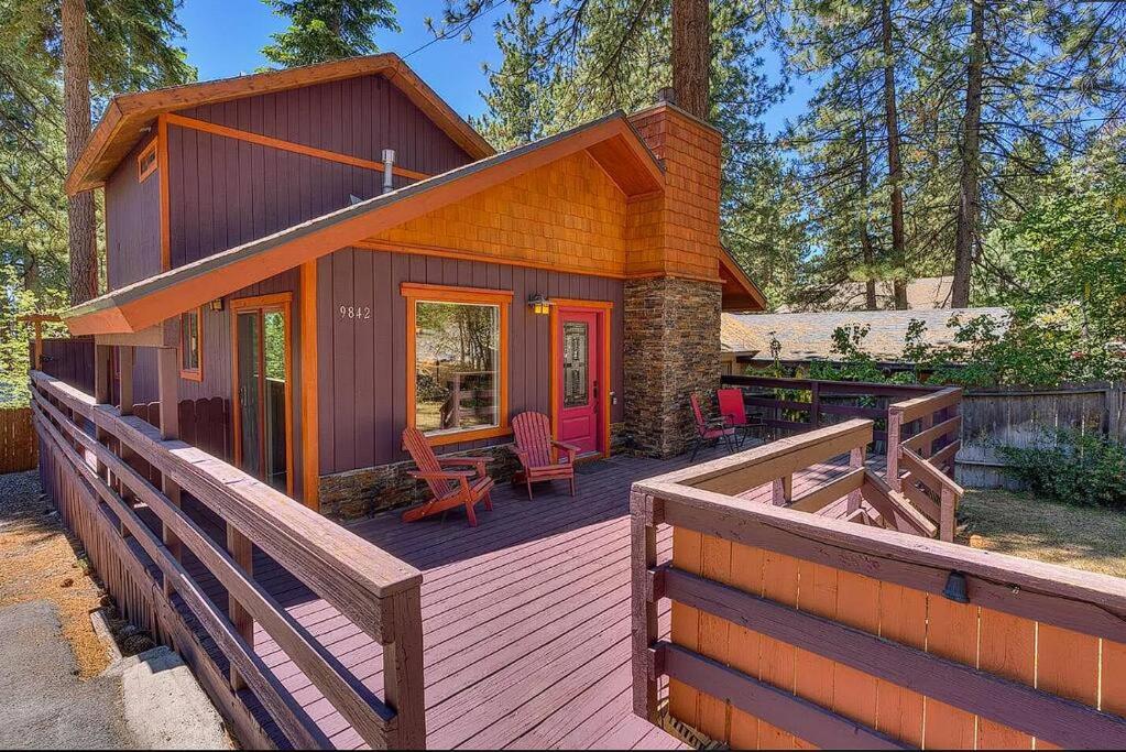 a wooden deck with a house with a red door at Lake Retreat House in Kings Beach