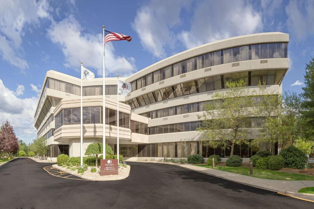 a building with an american flag in front of it at DoubleTree by Hilton Boston-Rockland in Rockland