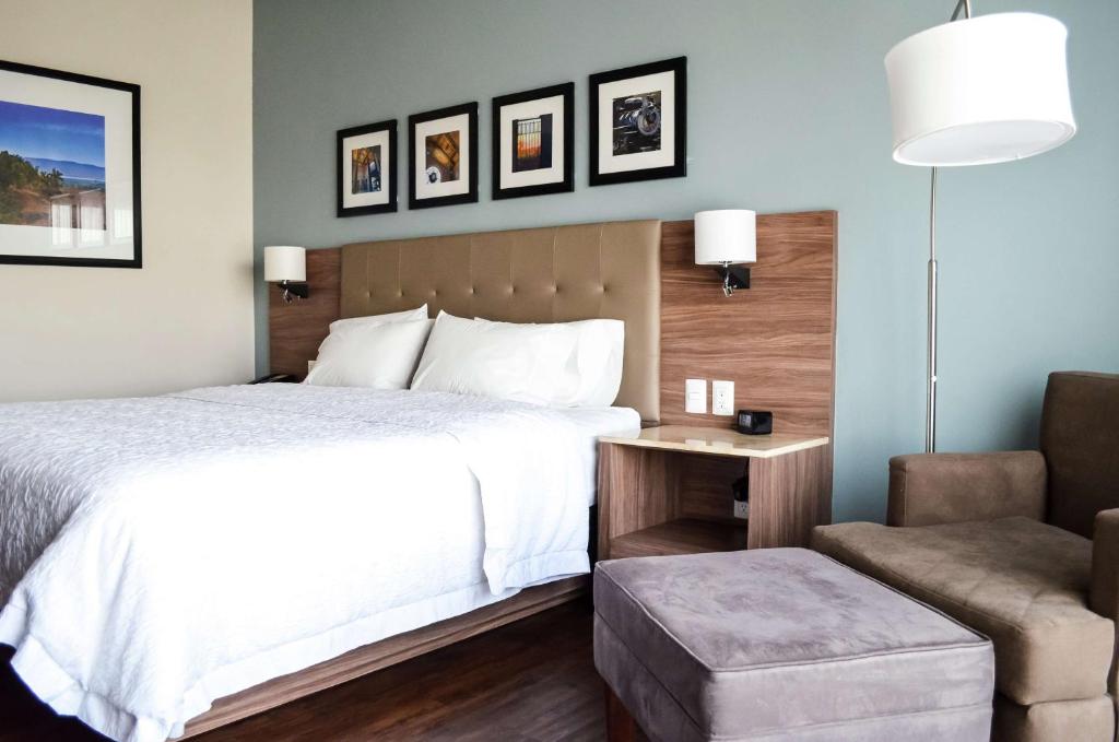 Habitación de hotel con cama y silla en Hampton Inn by Hilton Durango, en Durango