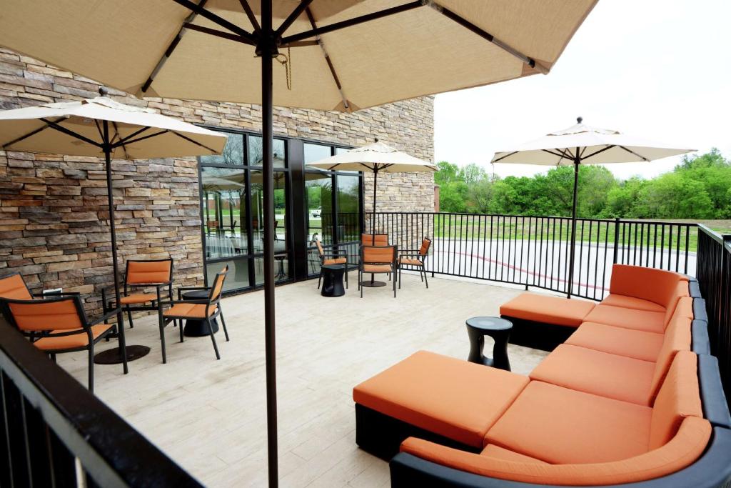 a patio with furniture and tables and umbrellas at Hampton Inn & Suites Ponca City in Ponca City