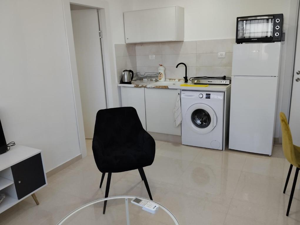 een keuken met een zwarte stoel en een wasmachine bij תות in Beer Sheva