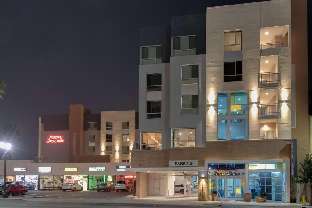 Hampton Inn & Suites Los Angeles - Glendale في غليندال: مبنى في الليل مع سيارات تقف في موقف للسيارات