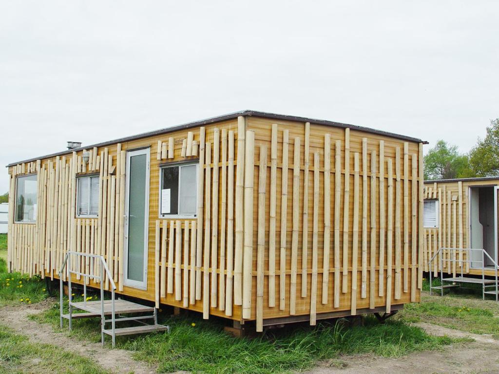 a row of yellow modular homes in a field at Ferienwohnung Rose in Loissin