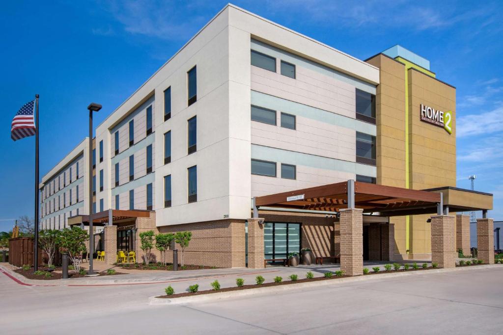 un edificio de hotel con una bandera americana delante de él en Home2 Suites By Hilton Waco, en Waco