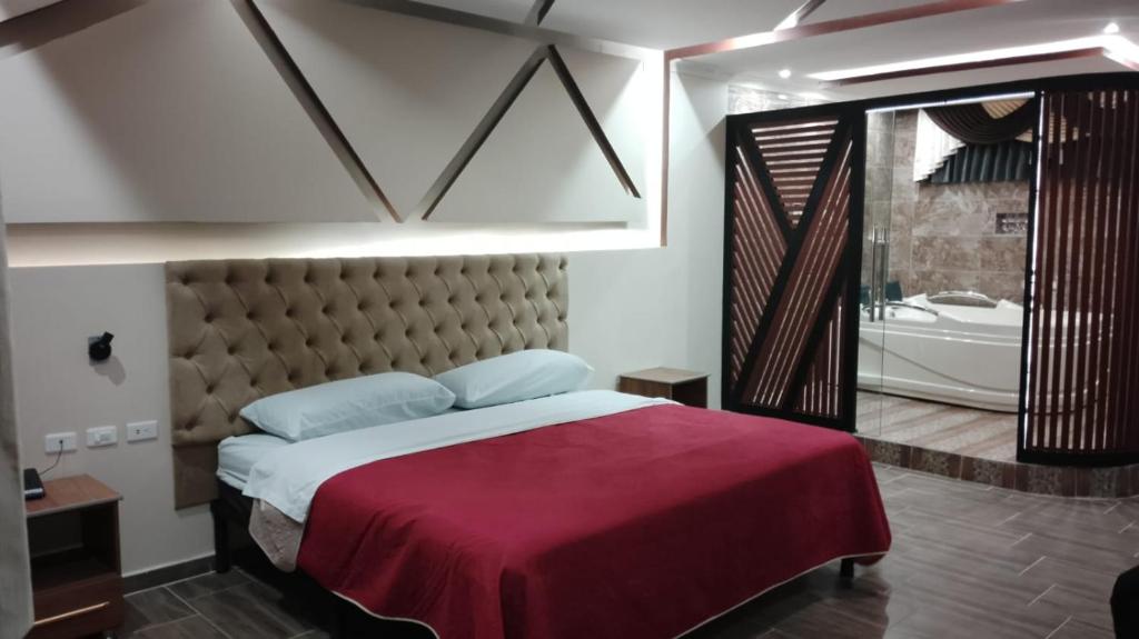 1 dormitorio con 1 cama grande y bañera en Hostal Boston 2 en Quito