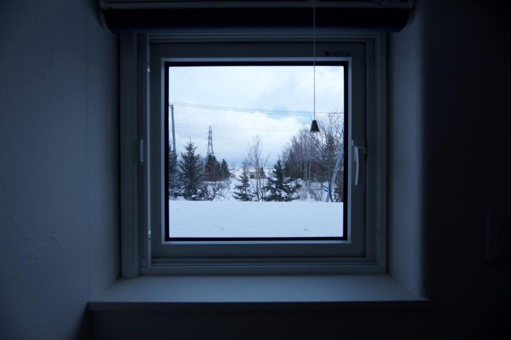 una ventana con vistas a un patio cubierto de nieve en HOTEL BOTH - Vacation STAY 90911v, en Shari