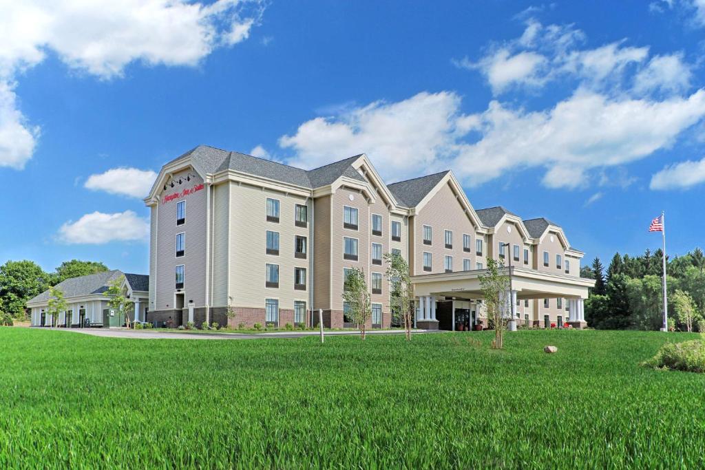 ein großes Gebäude mit einem Grasfeld davor in der Unterkunft Hampton Inn & Suites Cazenovia, NY in Cazenovia