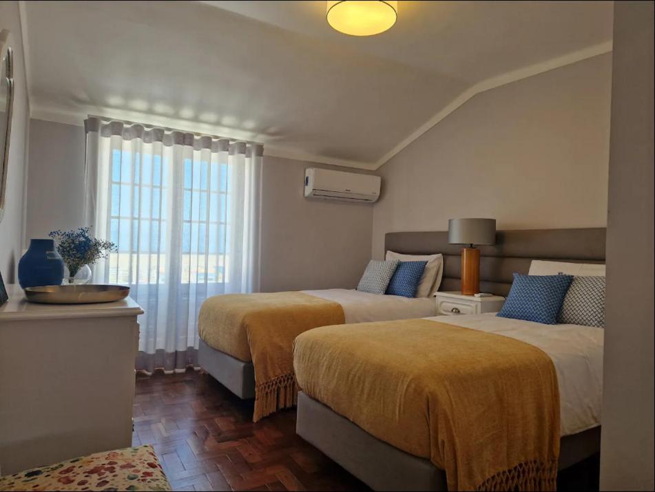 pokój hotelowy z 2 łóżkami i oknem w obiekcie Sun's House w mieście Ericeira
