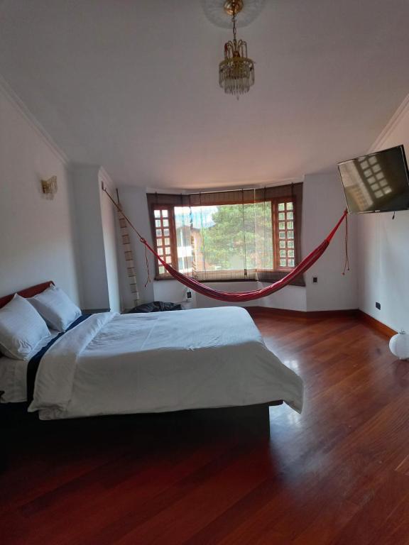 ein Schlafzimmer mit einem Bett mit einem roten Seil drum herum in der Unterkunft Gran habitación/jacuzzi/nor-occidente in Bogotá
