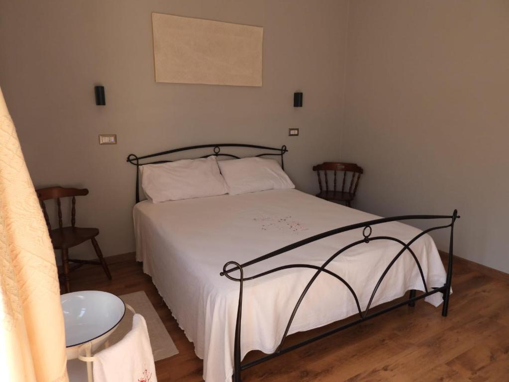 um quarto com uma cama com uma moldura de metal preto em Nonna Giusy em Alghero