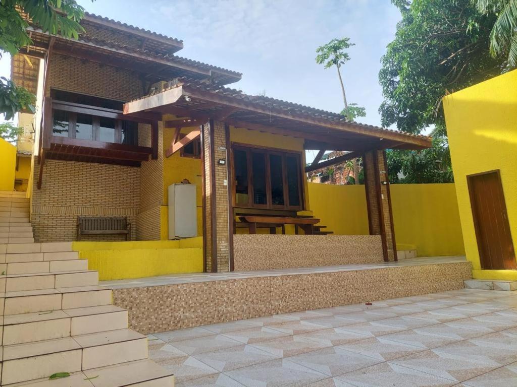 a yellow house with a table in the front of it at Pousada Solar dos Lençóis in Barreirinhas