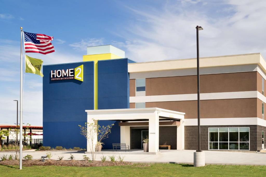 een kantoorgebouw met een Amerikaanse vlag ervoor bij Home2 Suites By Hilton Baton Rouge in Baton Rouge