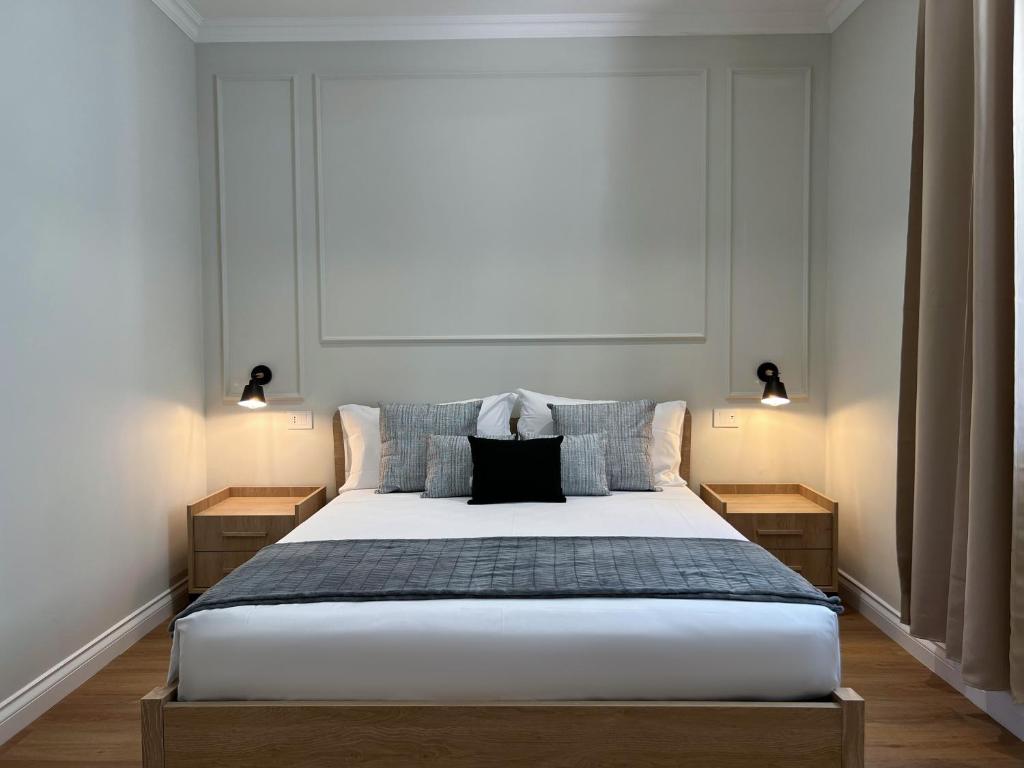 een slaapkamer met een groot bed met 2 nachtkastjes bij Cindy Rooms in Termoli