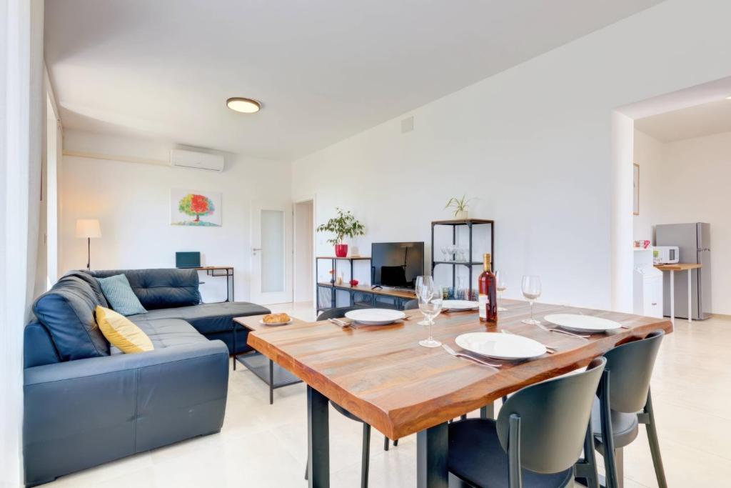 ein Wohnzimmer mit einem Holztisch und einem blauen Sofa in der Unterkunft NEW 2024 Apartment Marchesi Vodnjan in Vodnjan