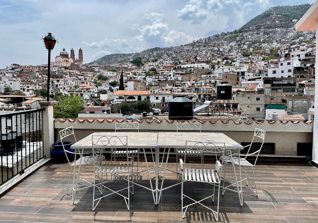 a table and chairs on a balcony overlooking a city at Casa céntrica con garaje in Taxco de Alarcón