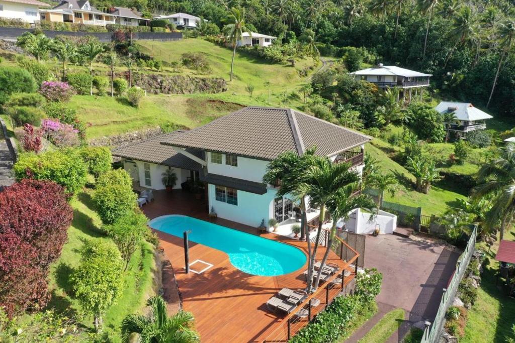 - une vue aérienne sur une maison avec une piscine dans l'établissement Villa Maroe (étage entier, deux chambres, salle de bain et cuisine), à Fare