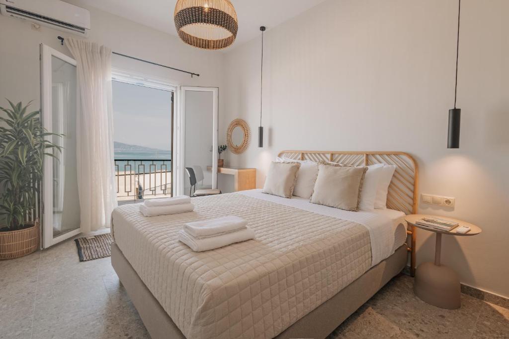 a bedroom with a bed with a view of the ocean at La Mer in Agios Rokkos