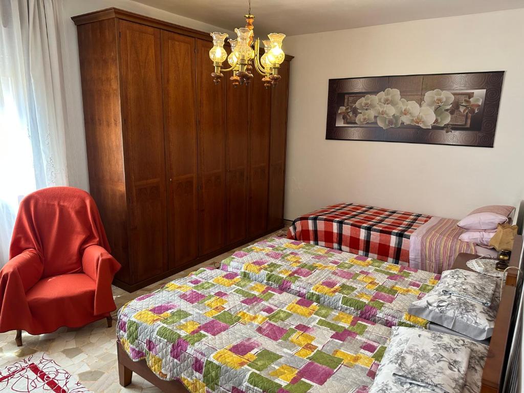 a bedroom with a bed and a chair at Casa Beccaria in Marghera