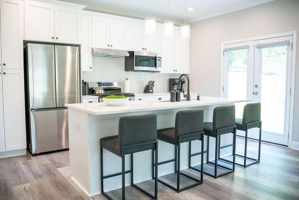 Hotel BRAND NEW: Urban Oasis 5 min from Mercedes Benz, a kitchen with a large white island with bar stools at BRAND NEW: Urban Oasis 5 min from Mercedes Benz in Atlanta