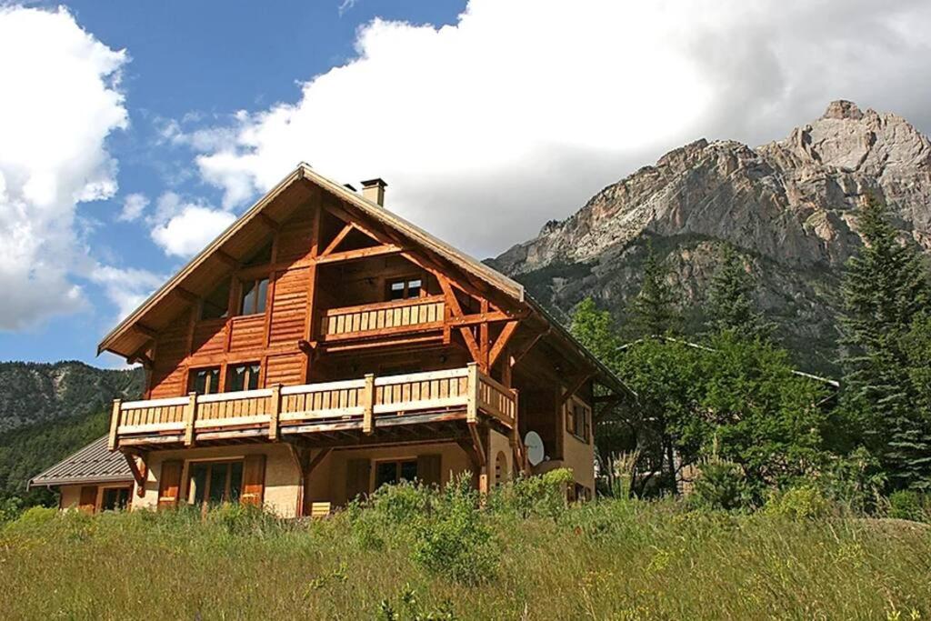 Cabaña de madera con balcón y montaña en CHALET 16 PERS PROCHE DES PISTES, en Vallouise