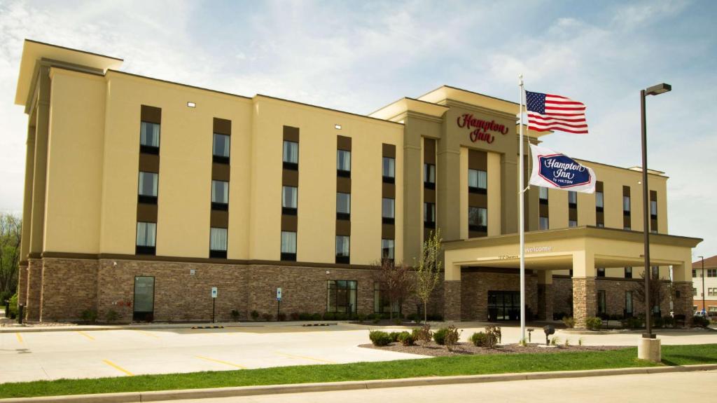 an exterior view of a hotel with an american flag at Hampton Inn Decatur, Mt. Zion, IL in Decatur