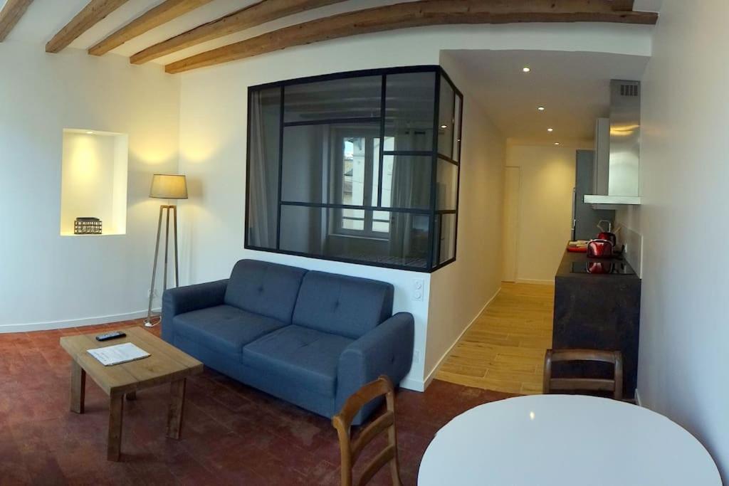 sala de estar con sofá azul y mesa en T2 tout équipé au beau milieu du centre historique, en Villefranche-sur-Saône