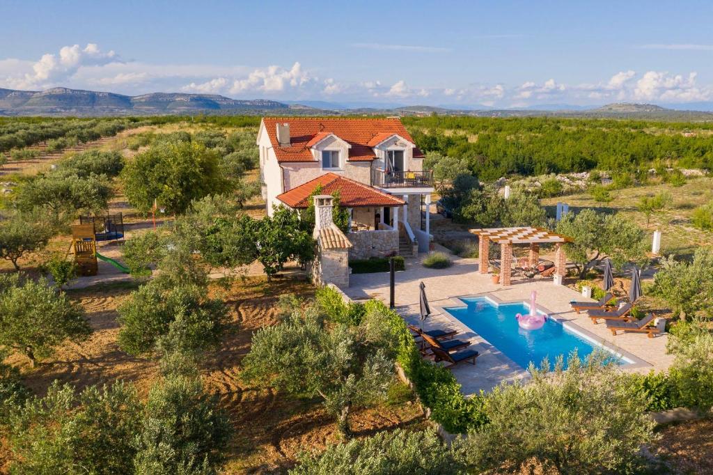 - une vue aérienne sur une maison avec une piscine dans l'établissement MY DALMATIA - Authentic Villa Storia with private heated pool, à Velika Čista