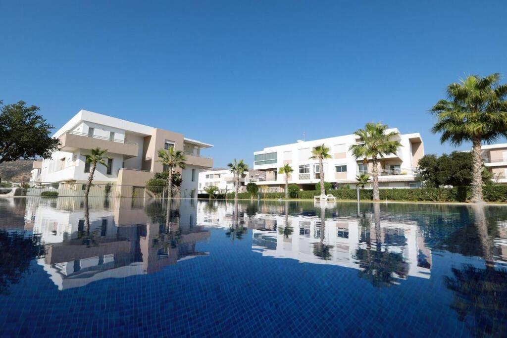 une grande piscine d'eau devant un bâtiment dans l'établissement Appartement avec piscine Imi ouaddar - Family only, à Agadir
