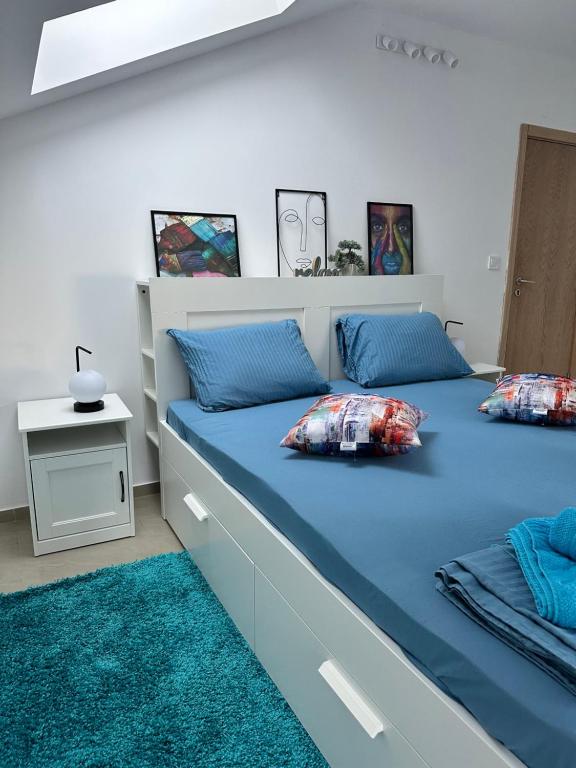 Un dormitorio con una cama grande con sábanas y almohadas azules. en Blue Central Apartment, en Veliko Tŭrnovo