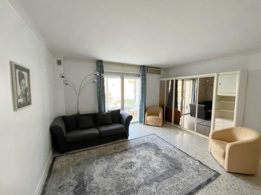 een woonkamer met een bank en een stoel bij Cool Appart sur Croisette Palm Beach in Cannes