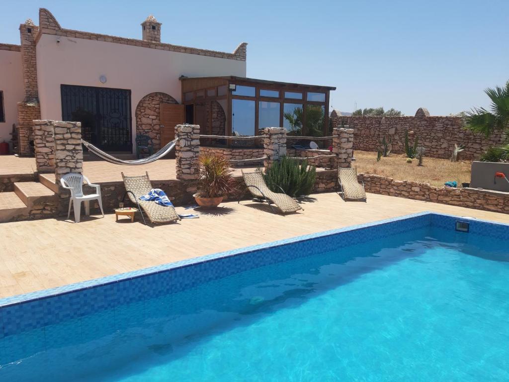 a swimming pool in front of a house at Villa Caroubier in Essaouira