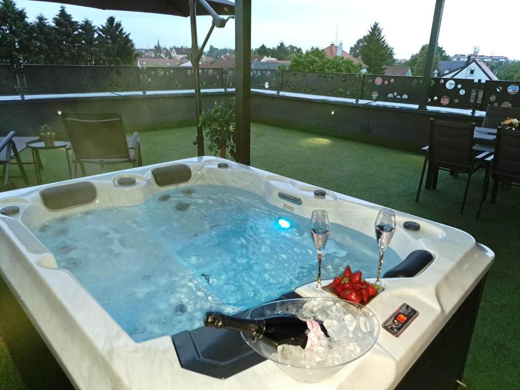 a hot tub with a bottle of wine and two glasses at Arcobaleno Apartments & Rooms in Varaždin