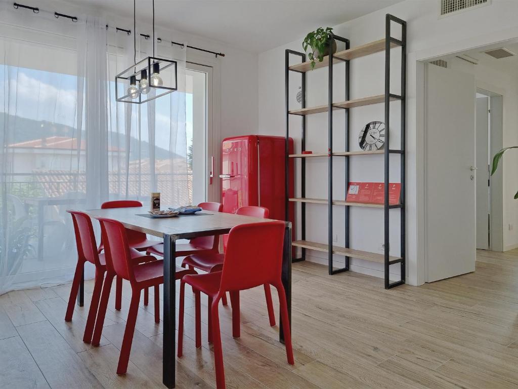 a dining room with a table and chairs and a red refrigerator at Pao Apartment - Costermano in Costermano
