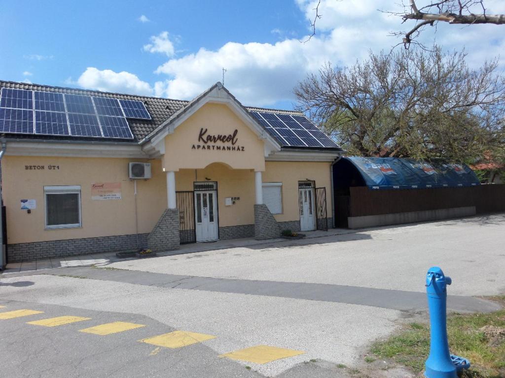 um edifício com painéis solares em cima em Karneol Apartmanház Cserkeszőlő em Cserkeszőlő