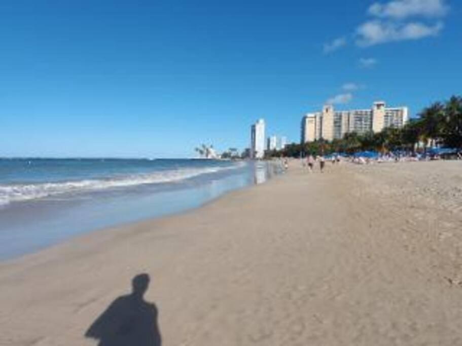 聖胡安的住宿－Oceana Trendy Ocean View Condo Hotel in Condado，站在海滩上的一个人的影子