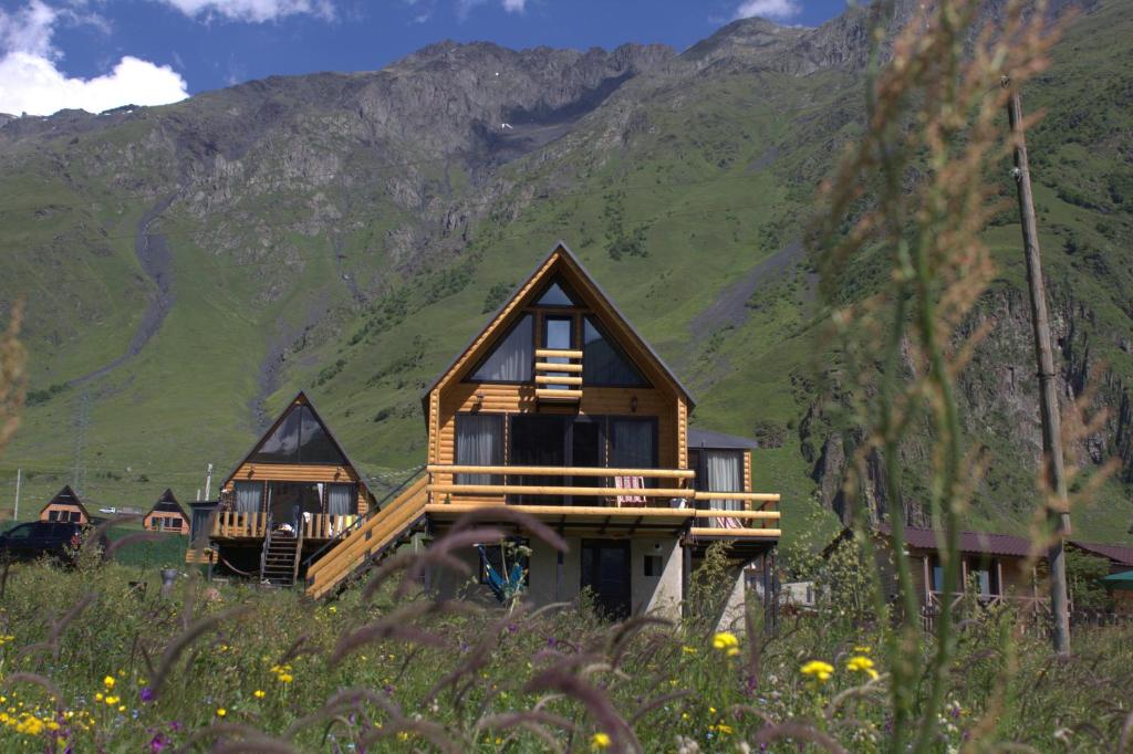 a group of cottages in front of a mountain at mood villa Kazbegi in Stepantsminda